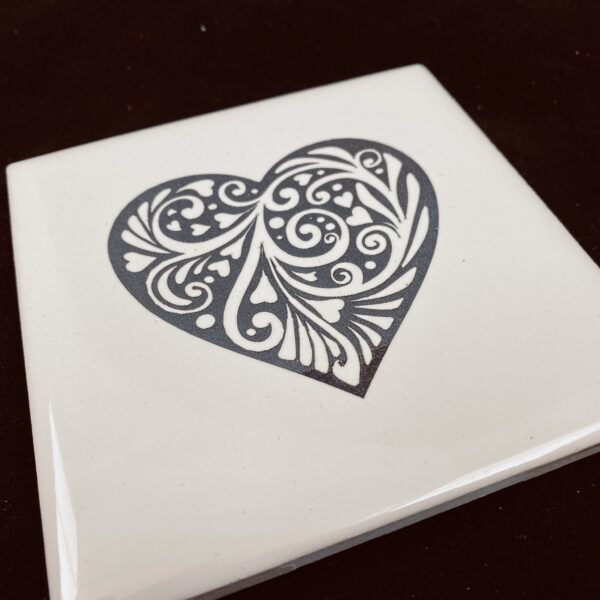 Image of engraved white coasters with decorative heart design - Donley Woodworking